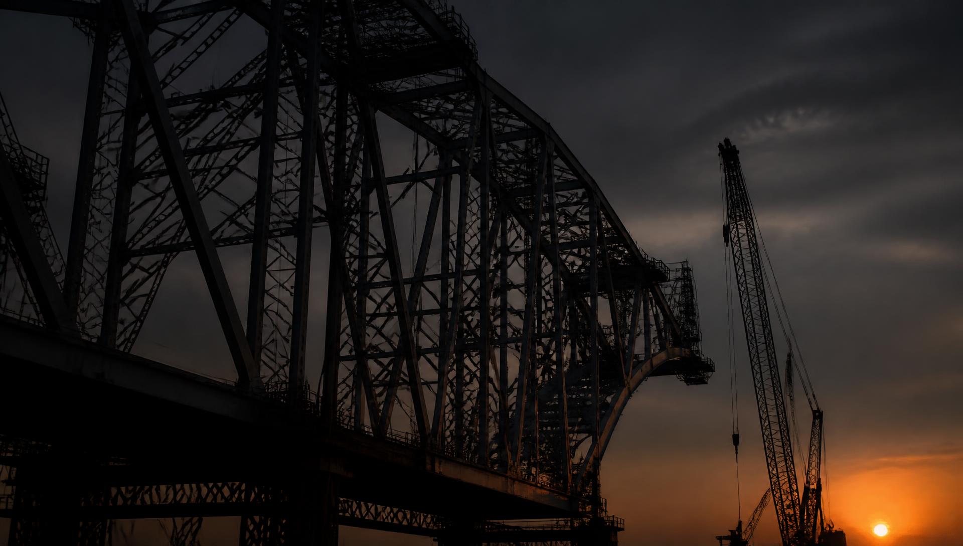 Steel lattice truss span under construction at dusk